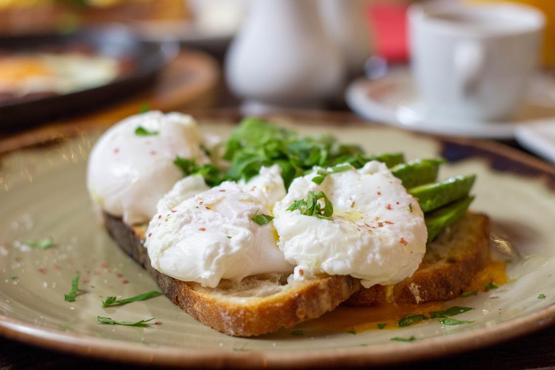Poached eggs on toast with avocado and fresh herbs
