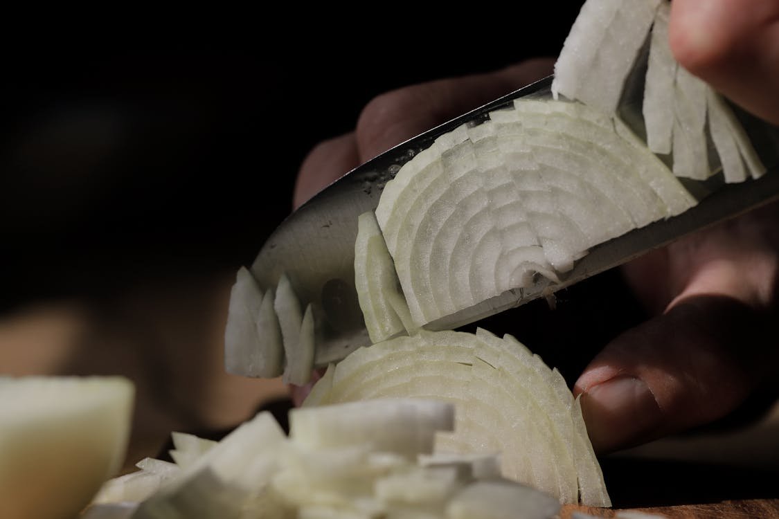 Close-up of slicing an onion showing the ring layers