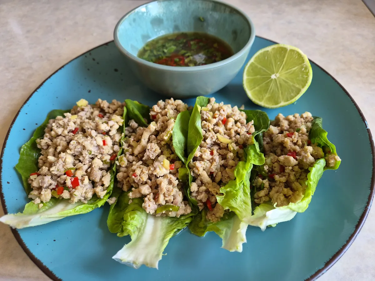 Chilli beef lettuce wraps overhead on a blue plate with dipping sauce and lime, cooked and photographed by reader Alex Sunins