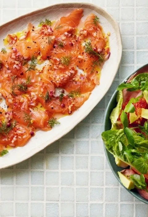 Gordon Ramsay salmon ceviche with thin raw salmon slices, red onion, pink peppercorns and fennel fronds beside a blood orange and avocado salad